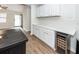 Kitchen featuring stylish cabinetry, stone countertops, wine cooler, and views into the living space at 521 Savannah Rd, Ladson, SC 29456