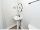 Powder room featuring modern fixtures, pedestal sink, and wood-look floor at 521 Savannah Rd, Ladson, SC 29456