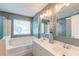 Well-lit bathroom with double vanity, large mirror, and soaking tub with shower attachment at 5400 Rock Creek Ct, North Charleston, SC 29420