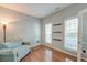 Cozy bedroom with hardwood floors, natural light from two windows, a comfortable couch, and simple shelving at 5400 Rock Creek Ct, North Charleston, SC 29420