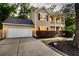 Inviting home with a two-car garage, covered porch, mature landscaping, and classic American flag at 5400 Rock Creek Ct, North Charleston, SC 29420