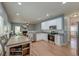 Open-concept kitchen and dining area with white cabinetry, stainless steel appliances, and hardwood floors at 5400 Rock Creek Ct, North Charleston, SC 29420