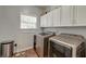 Laundry room features side-by-side washer and dryer and white upper cabinets at 5400 Rock Creek Ct, North Charleston, SC 29420