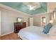 Elegant main bedroom with tray ceilings, hardwood floors, TV, and access to the ensuite bathroom at 5400 Rock Creek Ct, North Charleston, SC 29420