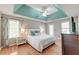 Spacious main bedroom featuring tray ceilings, hardwood floors, ceiling fan, and abundant natural light at 5400 Rock Creek Ct, North Charleston, SC 29420