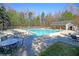 Community pool with lounge chairs and tables on a sunny day at 5400 Rock Creek Ct, North Charleston, SC 29420