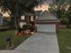 Charming two-story brick home with illuminated landscaping and a spacious driveway at twilight at 5403 Diston Ct, North Charleston, SC 29420