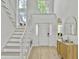 Bright foyer features high ceilings, staircase with large windows, and a stylish console table, all in a clean, white design at 5403 Diston Ct, North Charleston, SC 29420