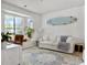 Bright living room with bay window, comfortable seating, and a surfboard wall accent at 5403 Diston Ct, North Charleston, SC 29420