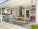 Covered outdoor patio complete with a ceiling fan, TV, picnic table, and decorative plants at 5403 Diston Ct, North Charleston, SC 29420