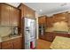 Kitchen with stainless steel refrigerator and microwave, as well as wooden cabinetry and granite countertops at 559 Eastern Isle Ave, Summerville, SC 29486