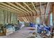 Spacious unfinished attic displaying exposed wooden beams, insulation, and two windows at 5950 Lowell Reed Rd, Ravenel, SC 29470