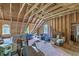 Large unfinished attic space with exposed wooden beams, a window, and stored items at 5950 Lowell Reed Rd, Ravenel, SC 29470