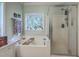 Soaking tub with a view of a shower behind a glass door at 5950 Lowell Reed Rd, Ravenel, SC 29470