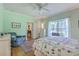 Bright bedroom with mint walls, highlighting a metal bed frame, hardwood floors, and large windows at 5950 Lowell Reed Rd, Ravenel, SC 29470