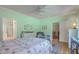 Light-filled bedroom with mint walls, showcasing a metal bed frame, hardwood floors, and an attached bathroom at 5950 Lowell Reed Rd, Ravenel, SC 29470