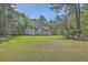 Exterior shot showing expansive yard and view of the home's design at 5950 Lowell Reed Rd, Ravenel, SC 29470