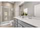 Bathroom featuring double sink vanity, white quartz countertop, tiled shower with glass doors, and neutral tile flooring at 607 Heartwood Ln, Summerville, SC 29486