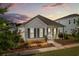 Attractive single-story home with a welcoming front porch is set against a backdrop of a colorful sunset sky at 607 Heartwood Ln, Summerville, SC 29486