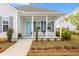 Inviting front porch with rocking chairs, charming columns, and a vibrant turquoise door enhances curb appeal at 607 Heartwood Ln, Summerville, SC 29486