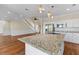 Open concept kitchen features granite countertops, an island, stainless appliances, and stairs to living area at 643 Backfield Rd, Walterboro, SC 29488
