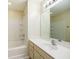 Clean bathroom featuring a tub-shower combination, tile surround, vanity with sink, and a large mirror at 8679 Grassy Oak Trl, North Charleston, SC 29420