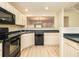 Well-lit kitchen featuring wooden floors, cream cabinets, and black appliances at 8679 Grassy Oak Trl, North Charleston, SC 29420