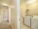 Functional laundry room with washer, dryer, and storage shelves at 8679 Grassy Oak Trl, North Charleston, SC 29420