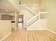 Open-concept living room with a staircase, wood flooring, and natural lighting at 8679 Grassy Oak Trl, North Charleston, SC 29420