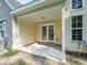 Covered patio area with white columns and ceiling, perfect for outdoor seating and relaxation with entry to the home at 8679 Grassy Oak Trl, North Charleston, SC 29420