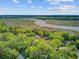 Picturesque aerial view of homes enveloped by lush trees, near a winding river and marshy wetlands at 8781 Laurel Grove Ln, North Charleston, SC 29420