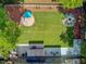Aerial shot showcases the fenced backyard with seating, a swing set, lush lawn, patio, and mature trees at 8781 Laurel Grove Ln, North Charleston, SC 29420