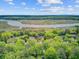 Stunning aerial shot of homes surrounded by dense trees, bordering a wide river and marshy landscape at 8781 Laurel Grove Ln, North Charleston, SC 29420