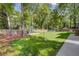 Beautifully landscaped backyard with a swing set, seating area, and mature trees, creating a serene outdoor oasis at 8781 Laurel Grove Ln, North Charleston, SC 29420