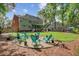 Large backyard featuring a gravel fire pit area, lush lawn, and a spacious patio for outdoor entertaining at 8781 Laurel Grove Ln, North Charleston, SC 29420