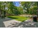Expansive backyard with a concrete patio, lush lawn, and mature trees, perfect for outdoor activities and relaxation at 8781 Laurel Grove Ln, North Charleston, SC 29420