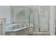 Bathroom with a large marble soaking tub and glass block window for privacy at 8781 Laurel Grove Ln, North Charleston, SC 29420