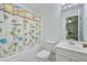 Bright bathroom featuring a white sink and toilet next to a tub with a playful animal-themed shower curtain at 8781 Laurel Grove Ln, North Charleston, SC 29420