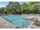 Community pool with crystal clear water, lounge chairs, and shaded umbrellas for residents to enjoy on sunny days at 8781 Laurel Grove Ln, North Charleston, SC 29420