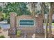 The brick community entrance sign for Riverbluff is surrounded by lush landscaping and mature trees at 8781 Laurel Grove Ln, North Charleston, SC 29420