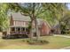 Traditional two-story red brick home with red shutters, mature landscaping, and a welcoming front porch at 8781 Laurel Grove Ln, North Charleston, SC 29420