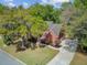 Stately brick home with a well-manicured lawn, mature trees, and a long driveway leading to a two-car garage at 8781 Laurel Grove Ln, North Charleston, SC 29420
