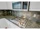 Close-up of gas range and granite countertop with stainless steel backsplash at 8781 Laurel Grove Ln, North Charleston, SC 29420