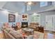 Bright living room showcasing a fireplace, hardwood floors, high ceilings, and comfortable seating arrangement at 8781 Laurel Grove Ln, North Charleston, SC 29420