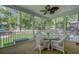 Relaxing screened-in porch with wicker furniture and a ceiling fan, overlooking the fenced backyard and pool at 8781 Laurel Grove Ln, North Charleston, SC 29420