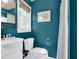 Small bathroom with teal walls, white fixtures, and natural light at 905 Simmons St, Mount Pleasant, SC 29464