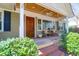 Inviting front porch featuring a wooden ceiling, exposed brick steps and classic wooden chairs at 905 Simmons St, Mount Pleasant, SC 29464