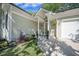 Covered front porch showcasing columns, potted plants, and a pair of charming white rocking chairs at 9146 Spring Branch Ct, North Charleston, SC 29406
