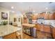 Open-concept kitchen with wood cabinets, a center island, and stainless steel appliances at 9146 Spring Branch Ct, North Charleston, SC 29406