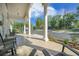 Inviting front porch with rocking chairs, columns and view of the manicured lawn and street at the I'On neighborhood in Mount Pleasant, SC at 9146 Spring Branch Ct, North Charleston, SC 29406